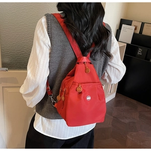 Dettaglio zaino rosso in nylon oxford con tasche multiple e cursori a forma di sorriso
