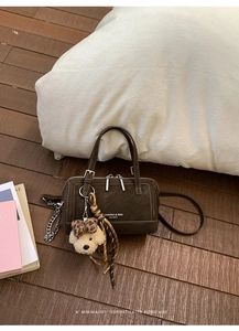 Vue détaillée du sac Boston marron foncé avec breloque chiot et cordon de décoration