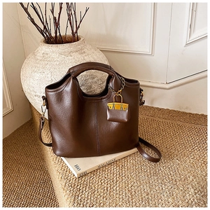 Détail d'un sac à main vintage marron foncé avec mini pochette et décor de magazine