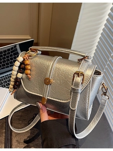 Chic silver metallic crossbody handbag with wrinkled leather texture and bead charm