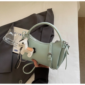 Detail of mint green half-moon crossbody bag with smooth leather and white pony charm