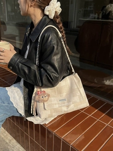 Borsa a tracolla beige testurizzata con logo in metallo e ciondolo di peluche