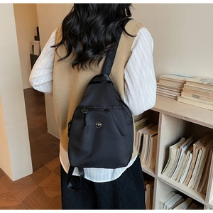 Dettaglio di una borsa a tracolla nera in tessuto oxford con cinturino regolabile