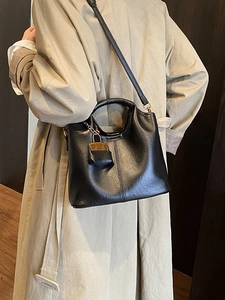 Sac à main minimaliste en cuir noir avec breloque marron et fine bandoulière réglable