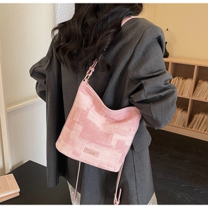 Dettaglio della borsa a secchiello in tela rosa con trama e etichetta in pelle