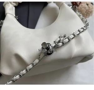 Detail of white PU leather texture with silver chain strap and adjustable spherical buckle