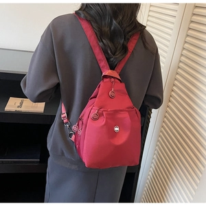 Vista posteriore dettagliata di uno zaino compatto in nylon bordeaux con scomparti multipli
