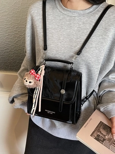 Vintage black leather backpack with faux fur detail and cute plush charm for women