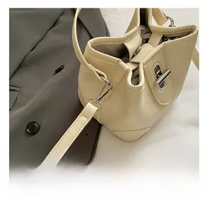 Close-up of litchi pattern leather bucket bag featuring a silver twist lock and hook