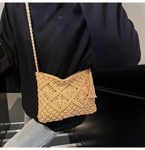 Detail of hand-woven beige crossbody bag with intricate cutout diamond patterns and tassels