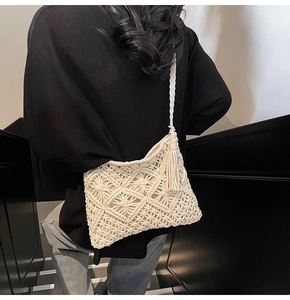 Detail view of cream macrame bag with geometric weaving and long side tassels