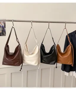 Detail view of four large capacity minimalist Hobo bags in brown, beige, black and tan colors