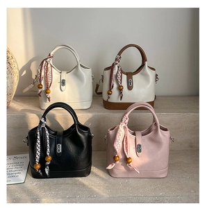 Détail de sacs seaux élégants avec poignées en soie et boucles en métal sur marbre