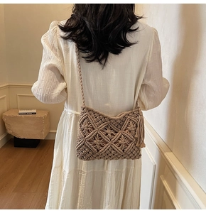 Detail of hand-woven bohemian crossbody bag with long fringes and hollow patterns