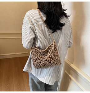Detailed back view of a woven straw crossbody bag with diamond patterns and side tassels