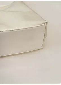 Detail view of reinforced base on a minimalist white tote bag with precision stitching