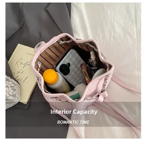 Detail view showing large internal capacity of pink drawstring backpack with chain strap