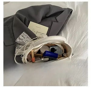 Vue de dessus montrant les compartiments de rangement du sac seau blanc avec foulard en soie