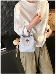 Detail of lavender bucket bag with silver twist lock and cute plaid bear pendant