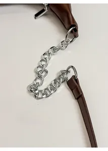 Close-up of dark brown faux leather bag with silver metal chain and polished strap detail