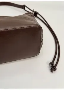 Detail of the structured base of this dark brown leather shoulder bag with fine stitching