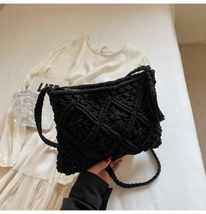 Detail of black macramé woven bag with handmade diamond texture and stylish long fringe