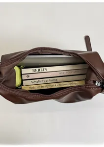 Top-down view of spacious dark brown tote bag interior with laptop and books