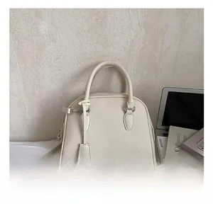 Detail shot of cream-white Boston bag in lychee texture leather with silver hardware
