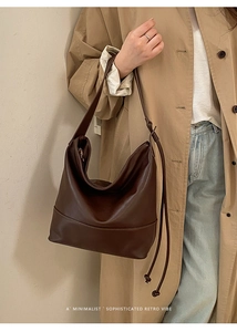 Detail of the brown oversized hobo bag showing its soft leather texture and stylish knot strap