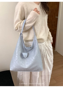 Detail of light blue hobo bag with wide shoulder strap and matching mini pouch pendant