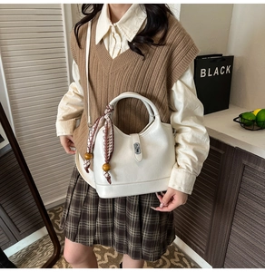 Détail du sac seau blanc avec foulard à carreaux et breloques en bois sur l'anse