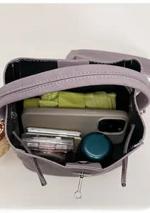 Top-down view of the spacious purple bucket bag interior with umbrella, phone and cup