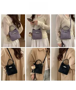 Detail of luxury bucket bag with leather drawstring and plush bear charm in multiple colors