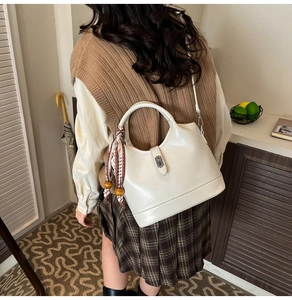 Vue arrière d'un mannequin portant un sac seau blanc cassé avec foulard en soie