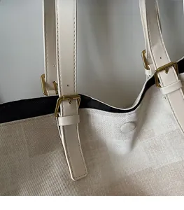 Detail view of adjustable leather strap and magnetic snap closure on the canvas tote bag