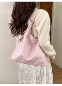 Pink slouchy tote bag shown on a model featuring a minimalist sophisticated retro vibe