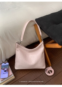 Dettaglio della borsa hobo rosa chiaro plissettata con hardware argento in casa