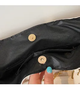 Detail of magnetic snap closure and black herringbone lining on a large tote bag