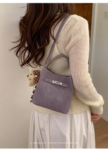 Detail of purple PU leather bucket bag with top handle and cute bear charm pendant