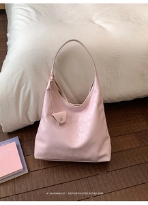 Detail of pink PU leather hobo tote bag featuring hanging coin purse and embossed logo