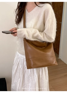 Brown retro large capacity shoulder bag showing minimalist style and draped shape on model