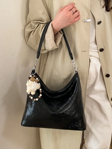 Borsa a spalla minimalista nera lucida con ciondolo in peluche e cinturino di perline
