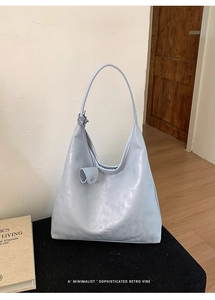 Detail of light blue hobo tote bag with branding and matching small coin purse accessory