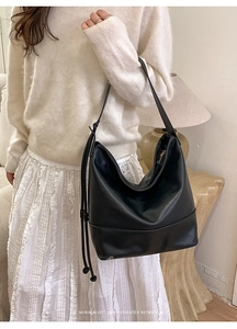 Detailed view of black hobo bag with retro leather texture and long tassel fringe decoration