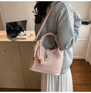 Détail du sac seau rose clair avec foulard à carreaux et perle en bois sur modèle