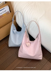 Detail of light blue and pink leather tote bags with matching mini pouches and long straps