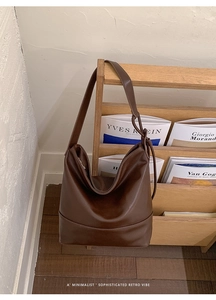 Detail of dark brown faux leather shoulder bag with smooth matte finish and tonal stitching