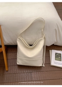 Detail view of cream leather shoulder bag with minimalist retro stitching and texture