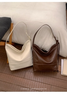 Close-up of minimalist retro tote bags in cream and coffee brown with adjustable straps
