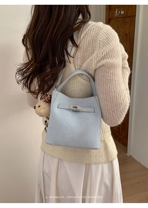 Detail of light blue bucket bag with silver twist lock and cute plush bear charm